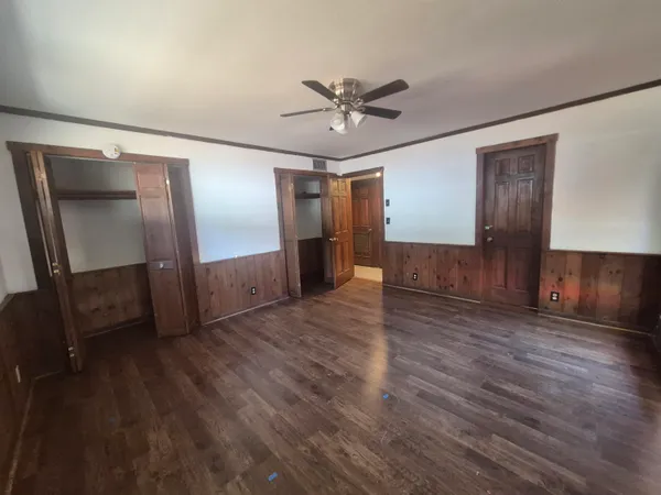 a view of empty room with wooden floor