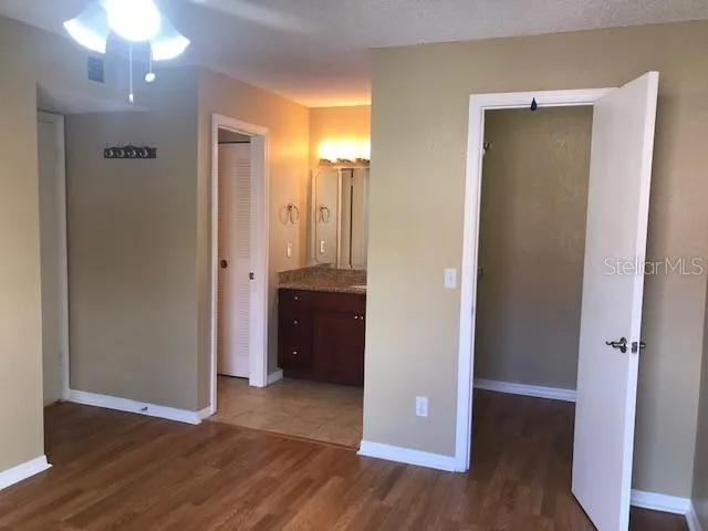 an empty room with wooden floor and a bathroom