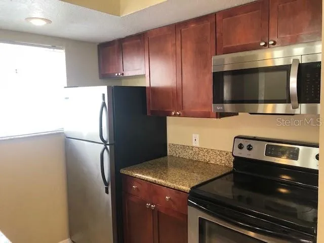 a kitchen with a refrigerator and a stove top oven