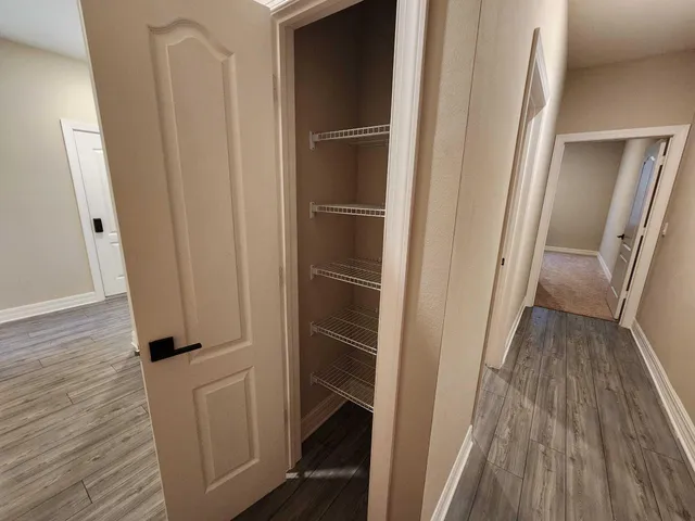 a view of closet with wooden floor