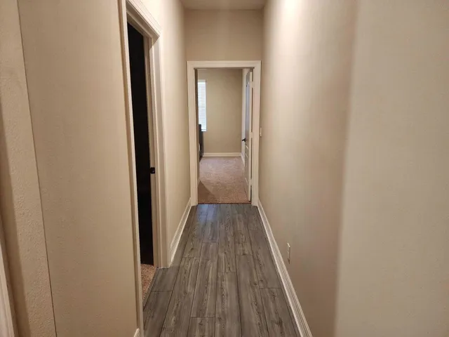 a view of a hallway with wooden floor