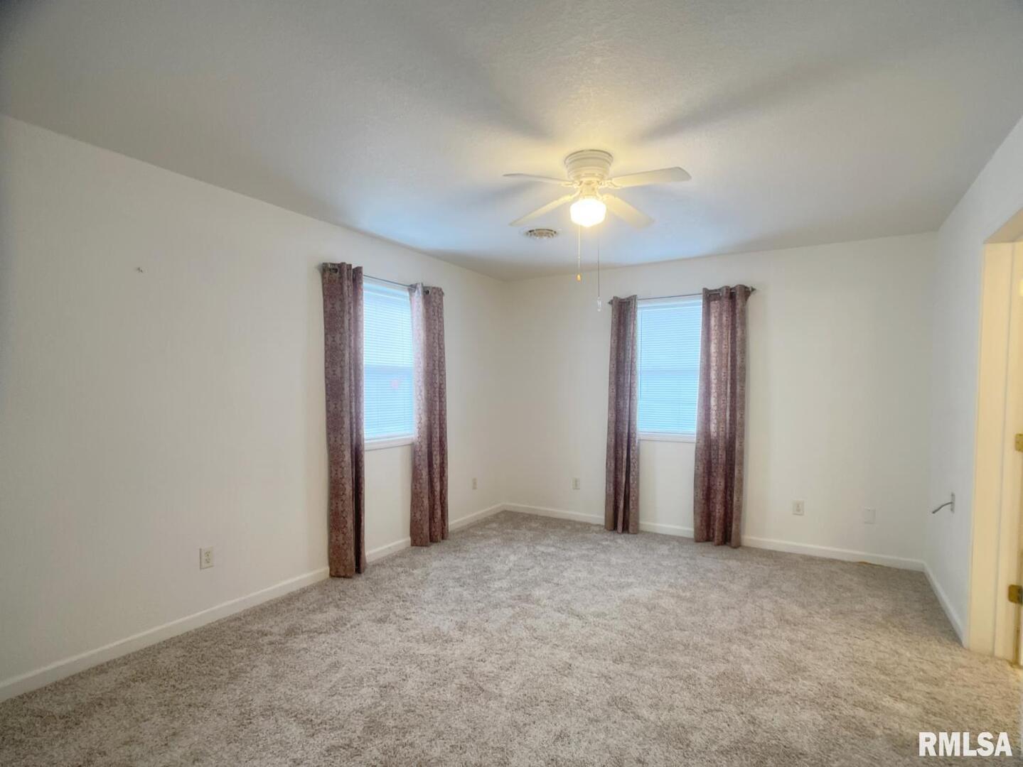 617 North 10th Street Herrin, IL 62948 - Photo 11 of 22 an empty room with windows and fan