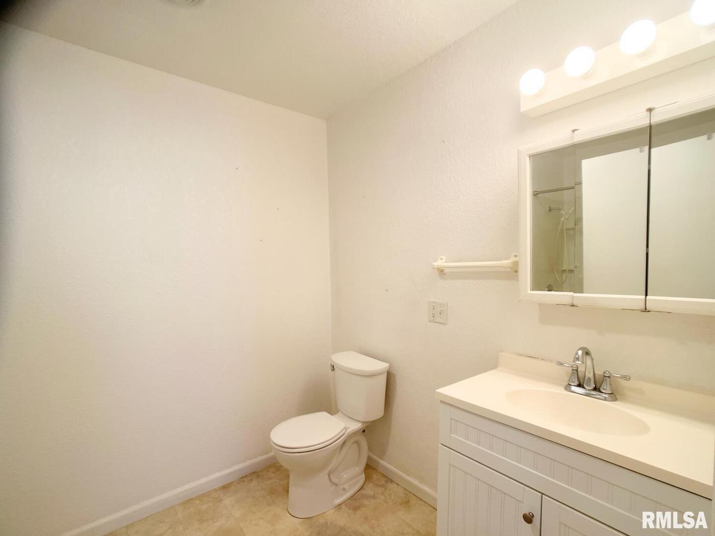 617 North 10th Street Herrin, IL 62948 - Photo 12 of 22 a bathroom with a granite countertop toilet and sink