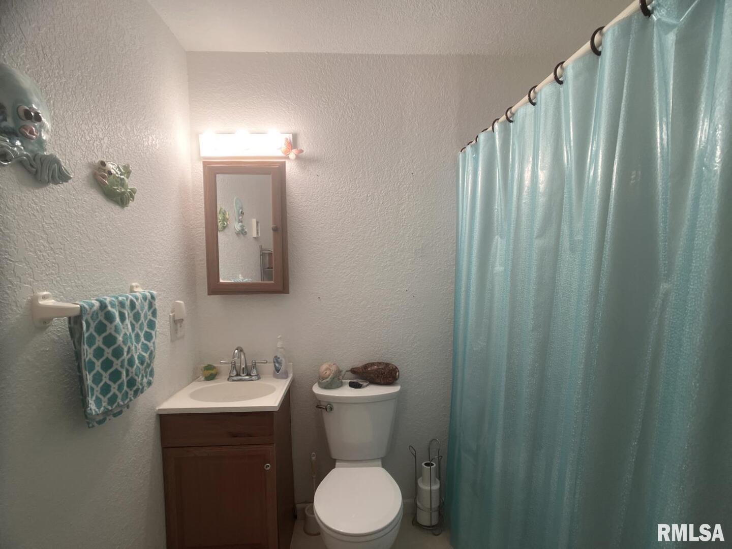 617 North 10th Street Herrin, IL 62948 - Photo 8 of 22 a bathroom with a toilet sink and mirror