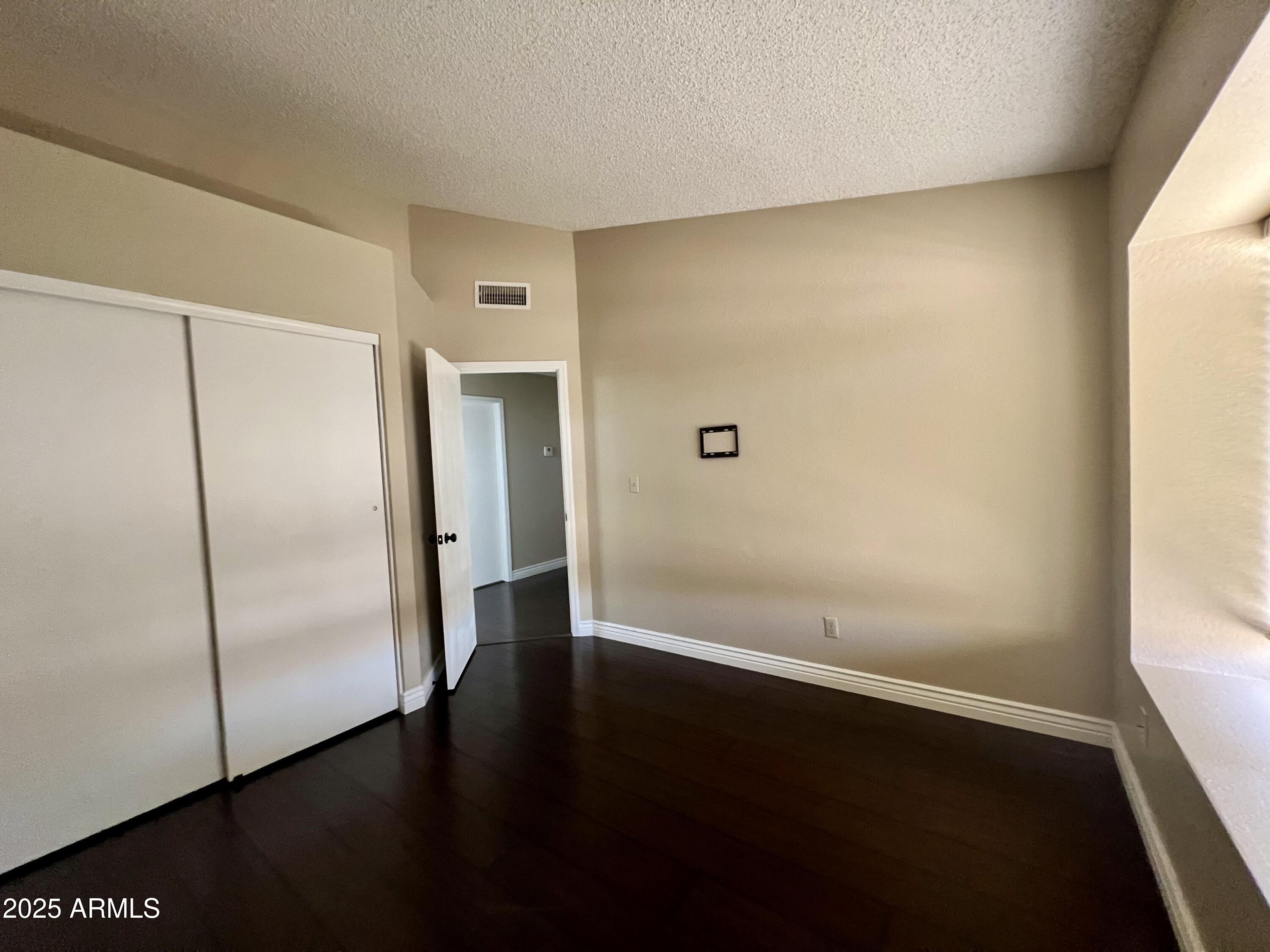 13643 South 36th Way Phoenix, AZ 85044 - Photo 14 of 32 a view of an empty room with wooden floor and a window