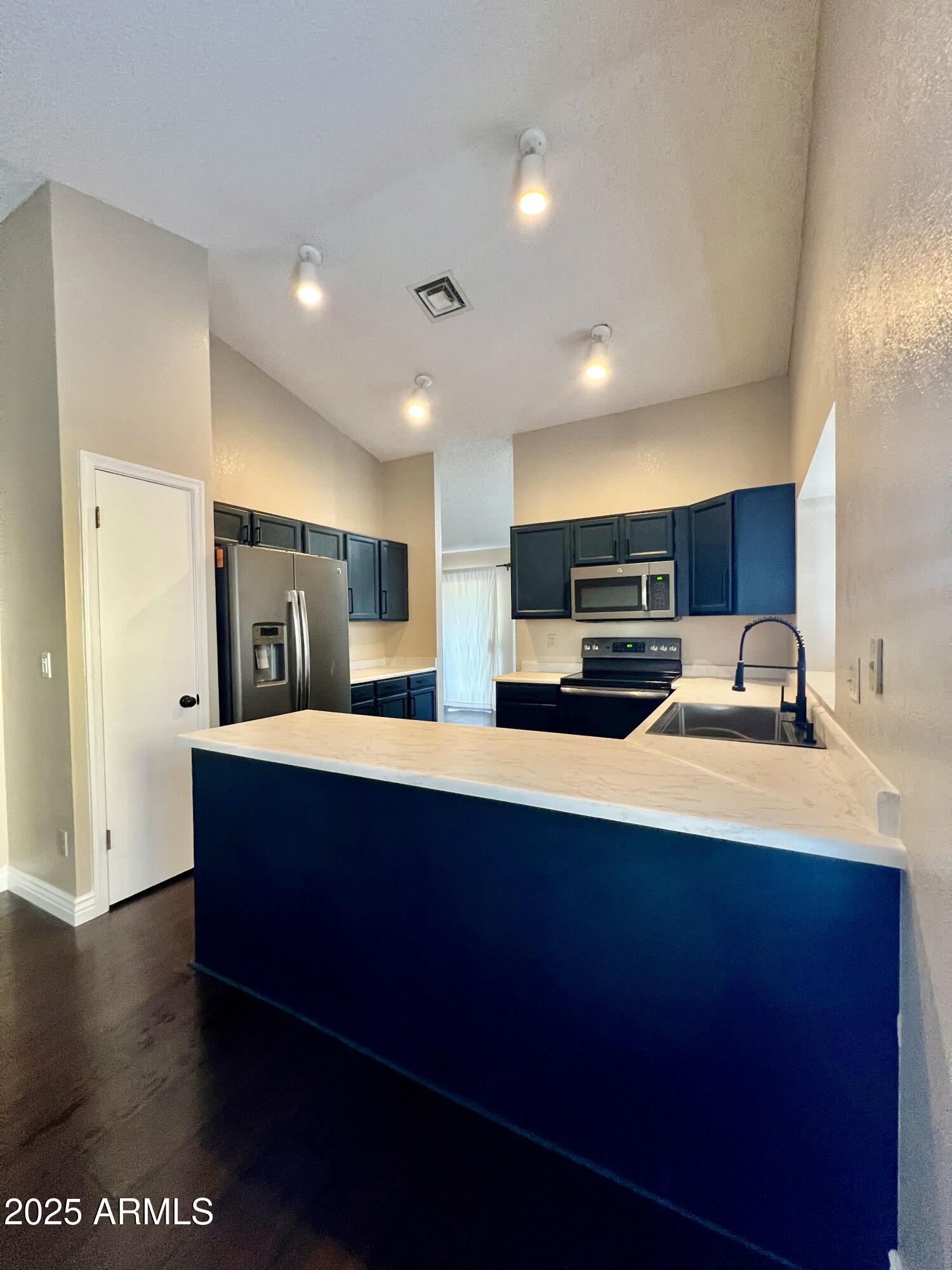 13643 South 36th Way Phoenix, AZ 85044 - Photo 2 of 32 a kitchen with stainless steel appliances a sink dishwasher a refrigerator and white cabinets with wooden floor