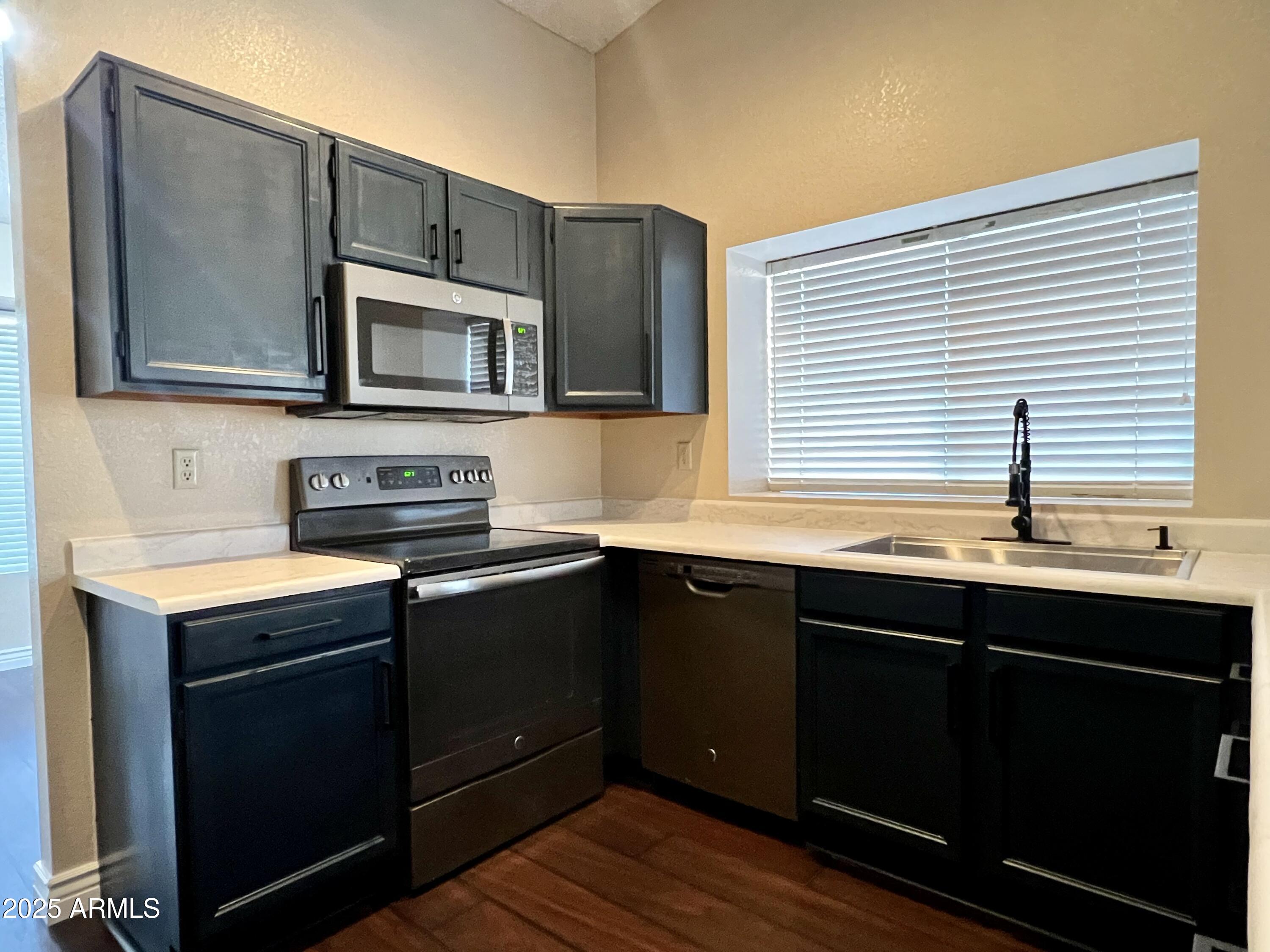 13643 South 36th Way Phoenix, AZ 85044 - Photo 4 of 32 a kitchen with stainless steel appliances granite countertop a sink and cabinets