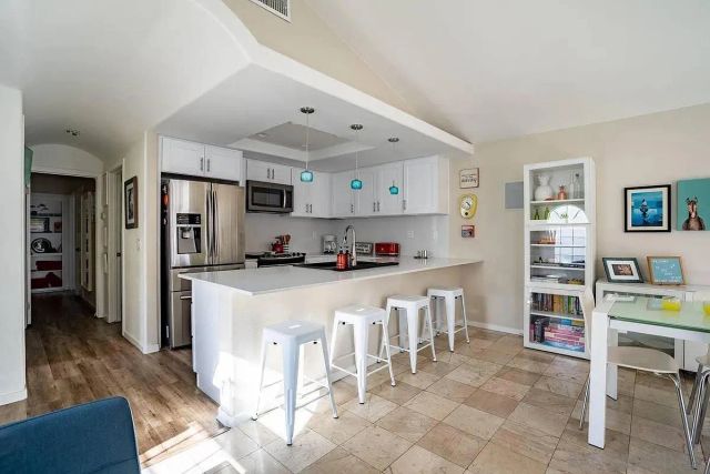 a kitchen with stainless steel appliances granite countertop a refrigerator and a stove top oven