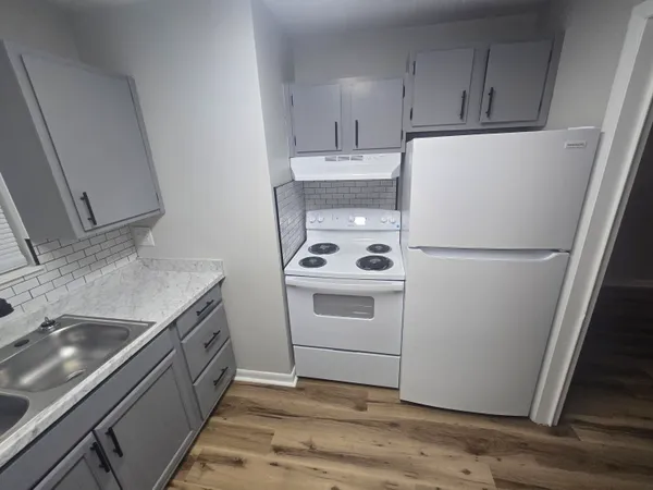 a kitchen with a sink a stove and cabinets