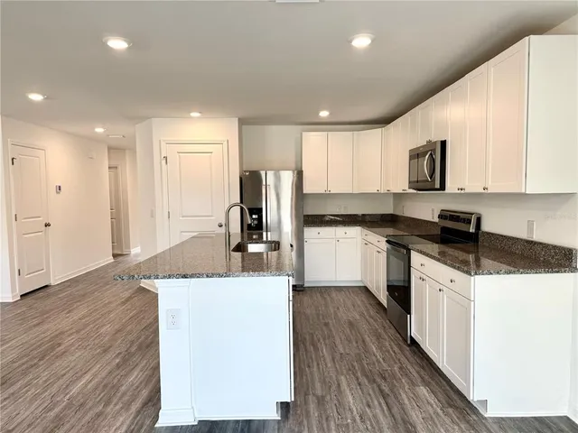 an empty room with wooden floor and a bathroom