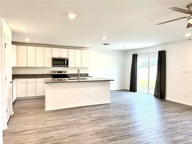 an empty room with wooden floor a ceiling fan and closet