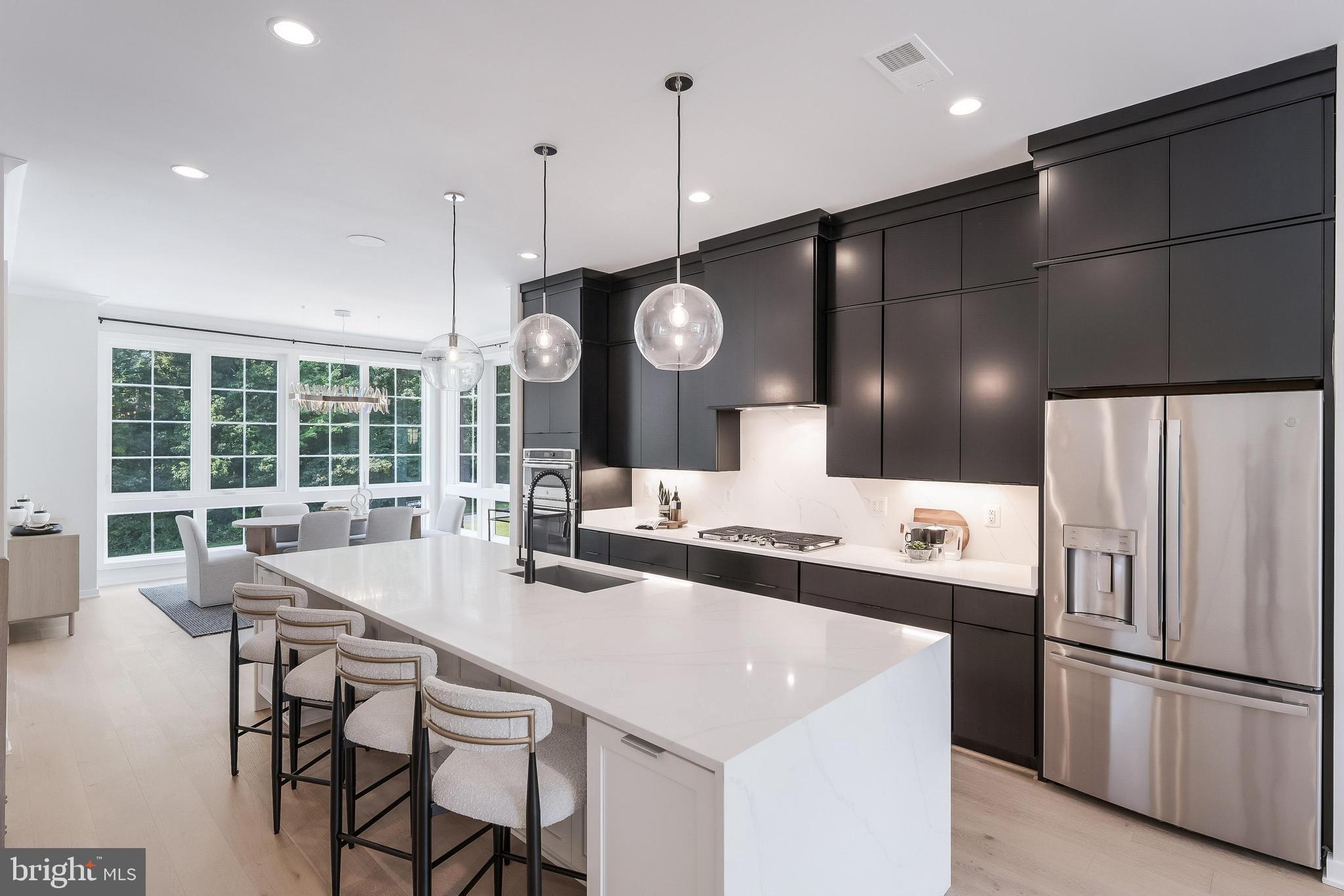 11748 Sunrise Valley Drive Reston, VA 20191 - Photo 18 of 60 a kitchen with stainless steel appliances a stove a refrigerator a sink with a dining table and chairs
