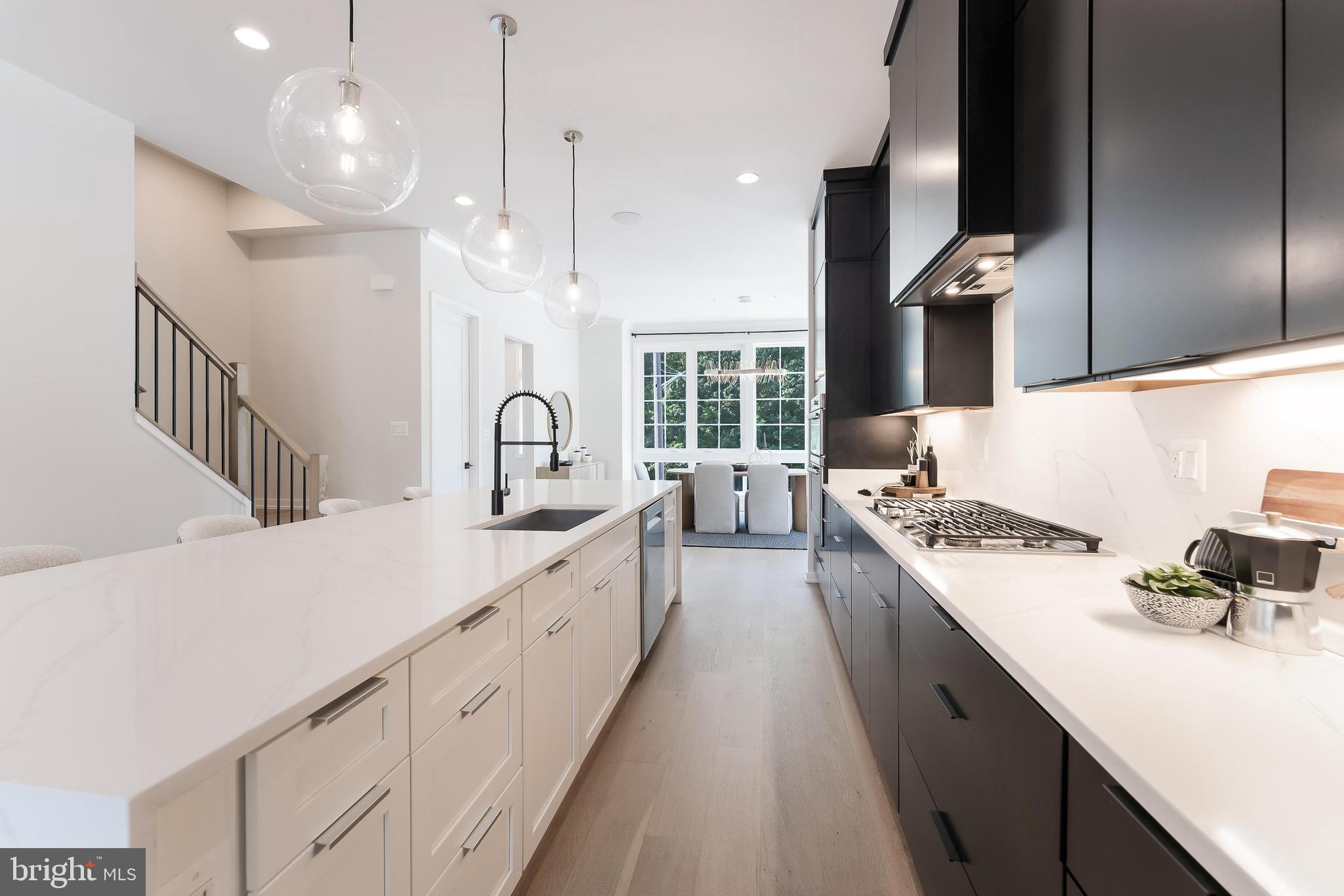 11748 Sunrise Valley Drive Reston, VA 20191 - Photo 19 of 60 a large kitchen with kitchen island a stove a sink dishwasher and a dining table with wooden floor