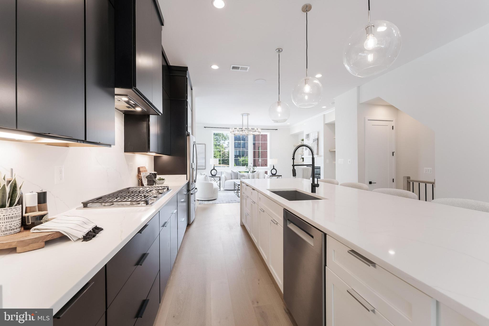 11748 Sunrise Valley Drive Reston, VA 20191 - Photo 22 of 60 a large kitchen with kitchen island a sink stove and wooden floor