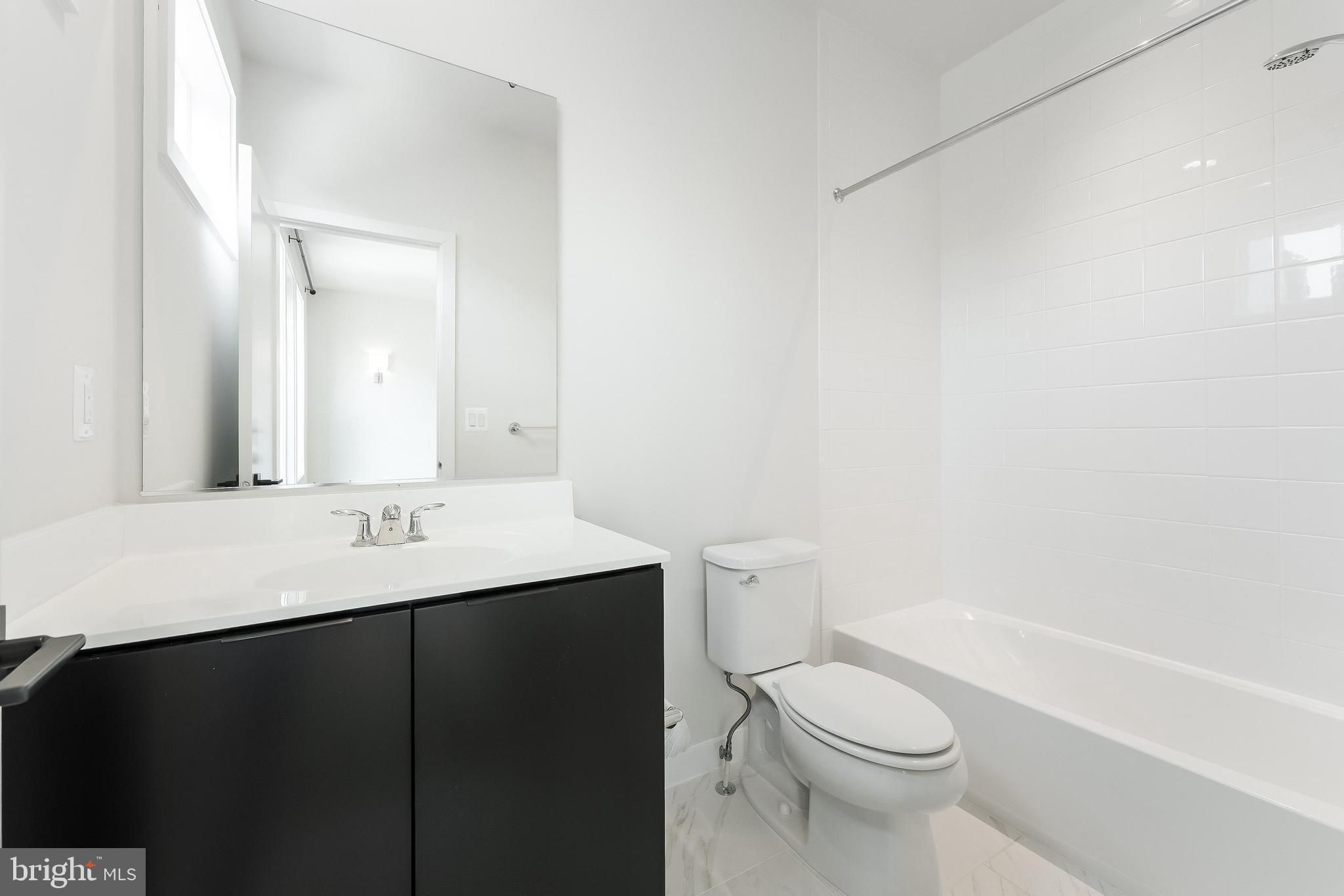 11748 Sunrise Valley Drive Reston, VA 20191 - Photo 35 of 60 a bathroom with a sink a toilet and shower