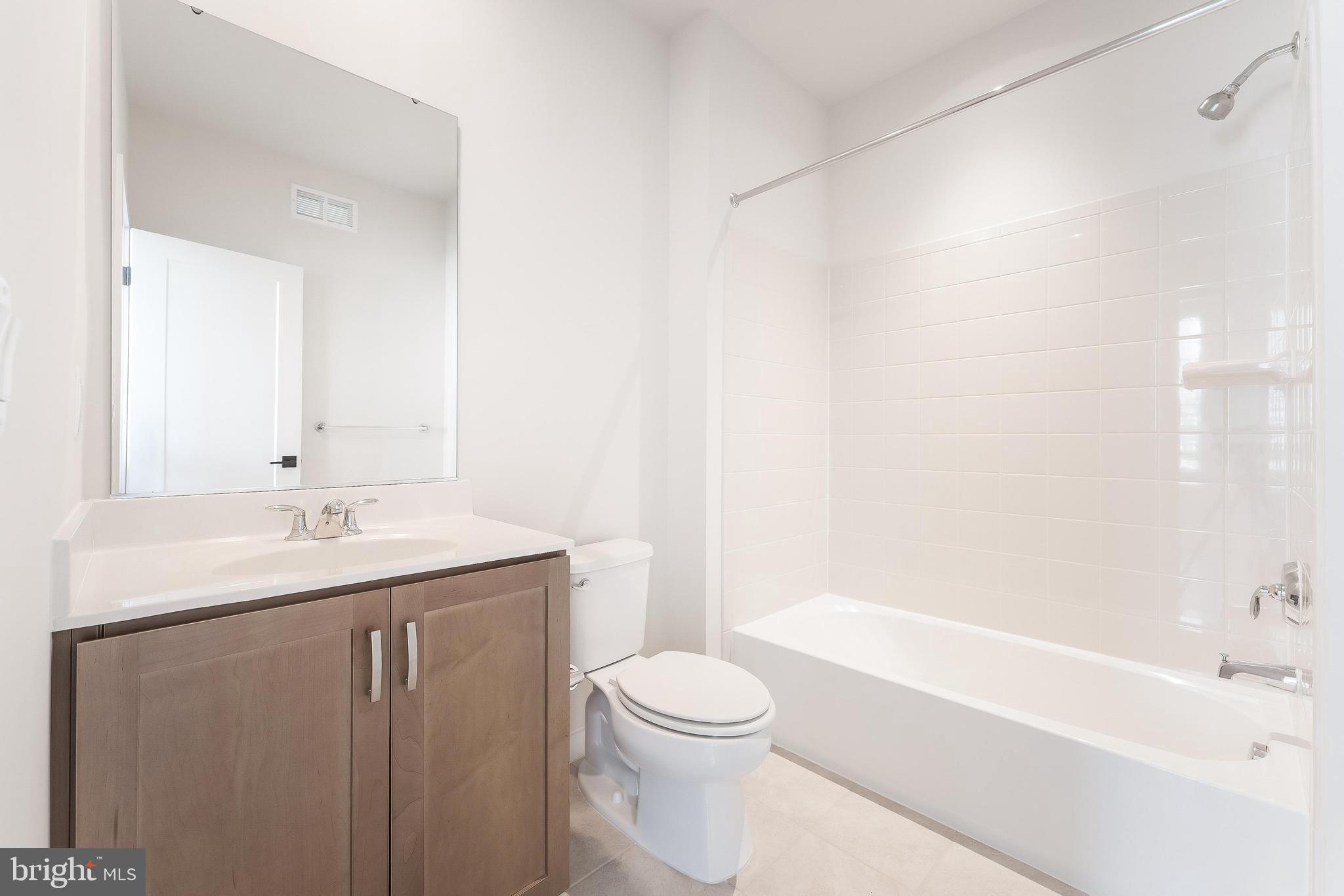 11748 Sunrise Valley Drive Reston, VA 20191 - Photo 49 of 60 a bathroom with a granite countertop sink a toilet and shower