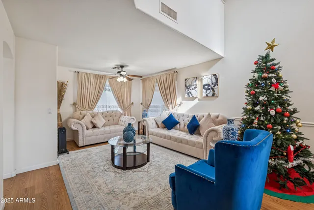 a living room with furniture flowers and a chandelier