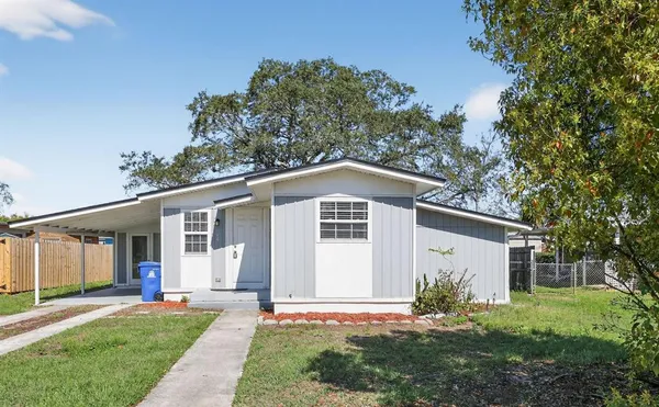 a front view of a house with a yard and trees