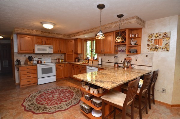 259 Green Road Bolton, MA 01740 - Photo 9 of 24 a kitchen with stainless steel appliances granite countertop a sink a stove and a refrigerator