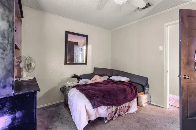a bedroom with a bed and a lamp on the dresser
