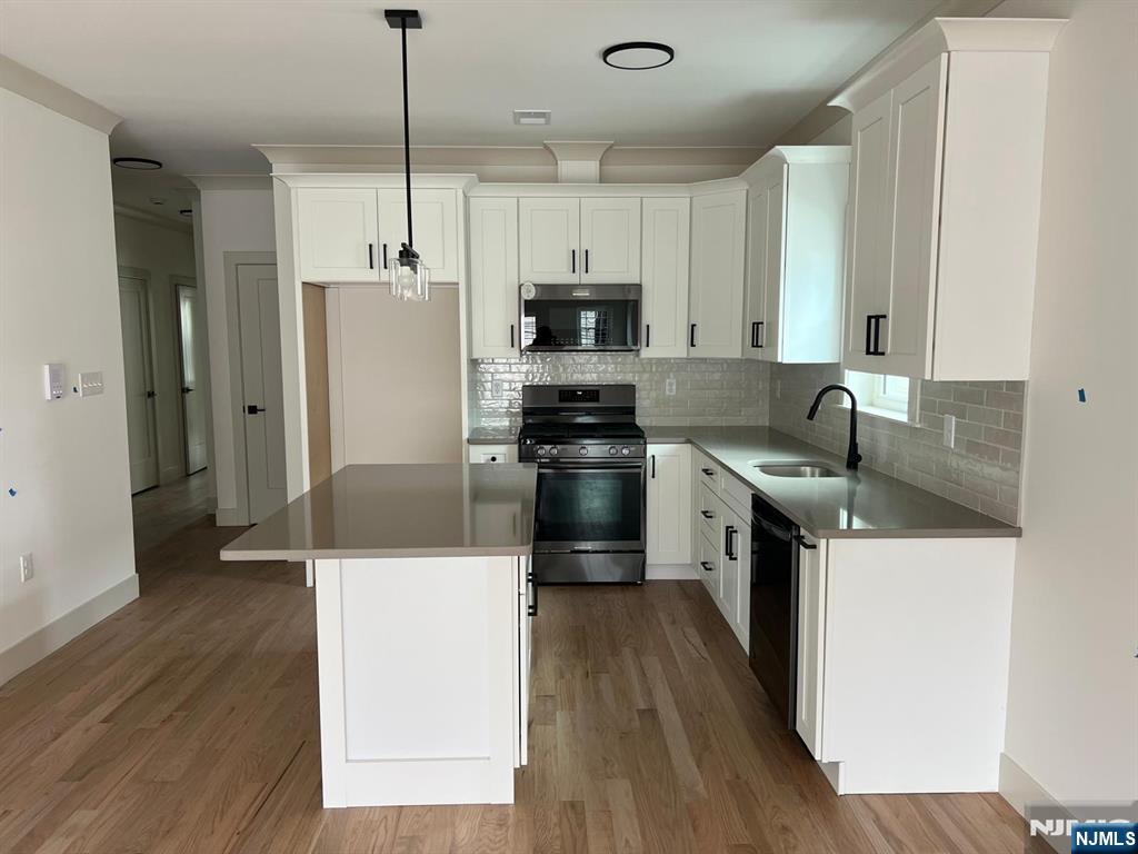 1060 Magnolia Avenue Elizabeth, NJ 07201 - Photo 13 of 22 a kitchen with a sink a refrigerator a microwave and cabinets