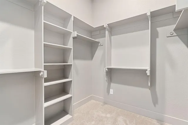 a view of walk in closet with empty racks