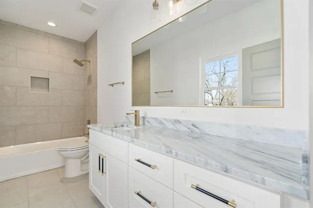 a bathroom with a granite countertop sink a toilet and a bathtub