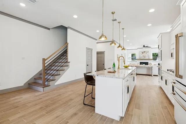 a living room with stainless steel appliances kitchen island granite countertop furniture wooden floor and a view of kitchen