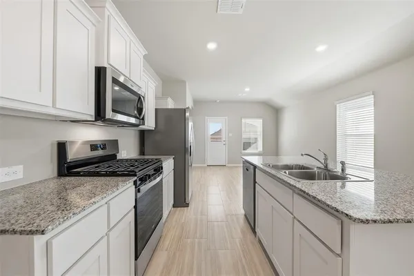 a kitchen with granite countertop a sink and steel appliances