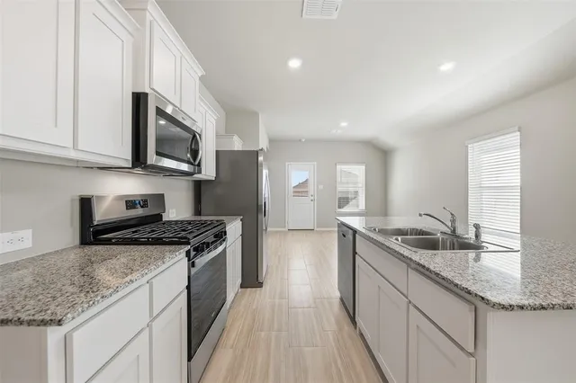 a kitchen with granite countertop a sink and steel appliances
