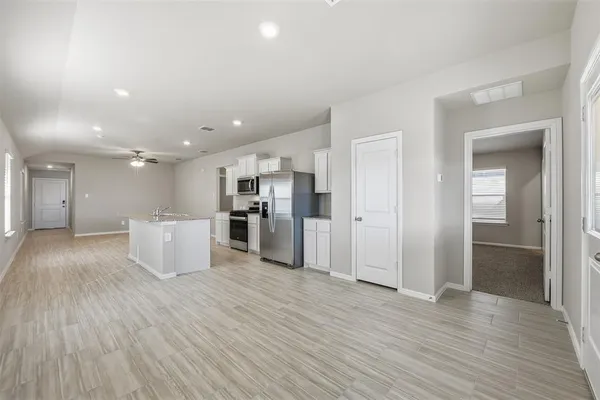 a view of a kitchen with wooden floor and electronic appliances