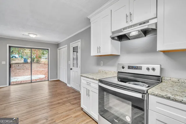 a kitchen with white cabinets and appliances