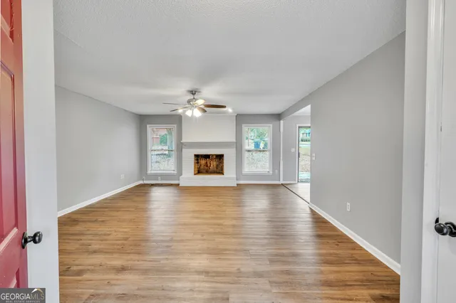 a view of empty room with wooden floor and fireplace