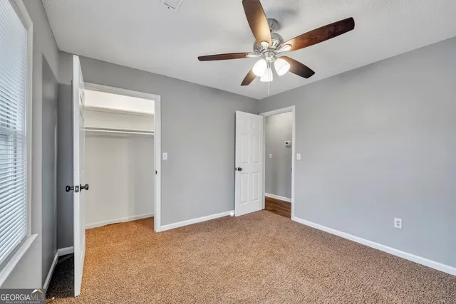 a view of a livingroom with a ceiling fan and window