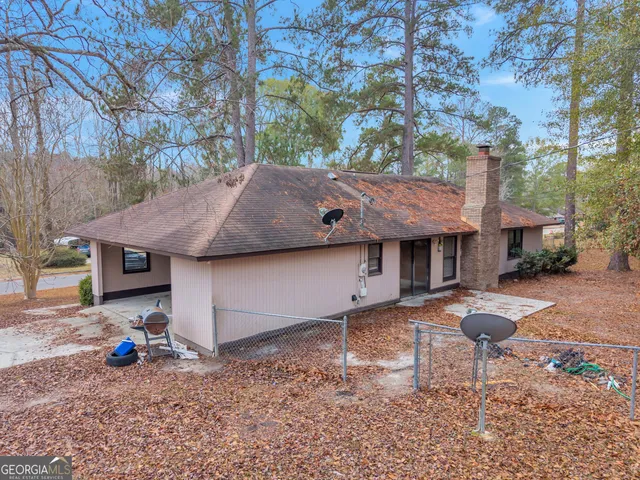 a yellow house with trees in front of it