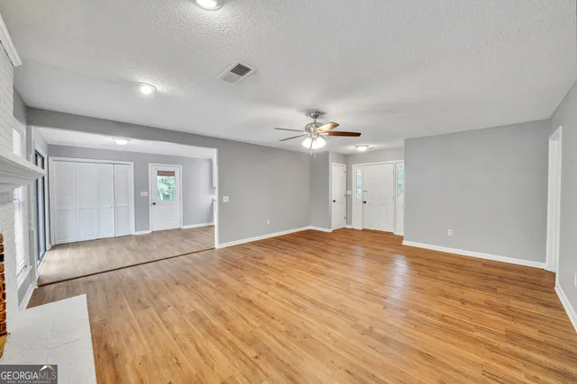 a view of empty room with wooden floor