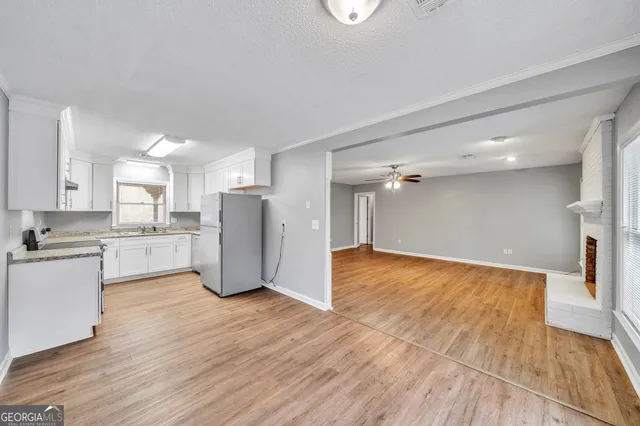 a view of open kitchen with wooden floor and electronic appliances