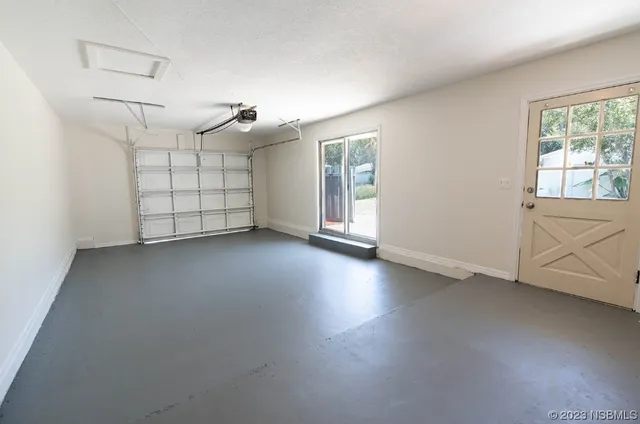 an empty room with windows and ceiling fan