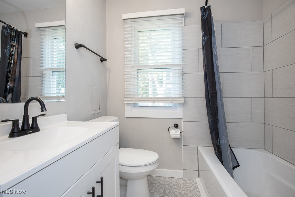 5607 Ridgewood Avenue Parma, OH 44129 - Photo 11 of 23 Full bathroom featuring tile patterned flooring, toilet, vanity, and shower / tub combo with curtain