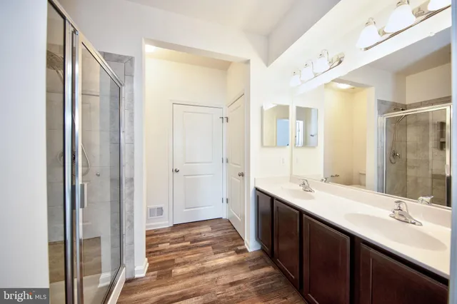 a bathroom with a double vanity sink and mirror