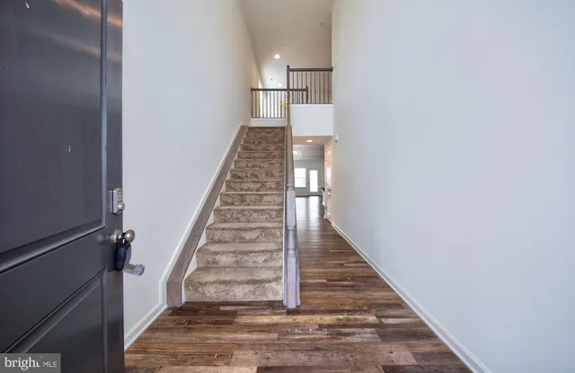 a view of a hallway with wooden floor and staircase