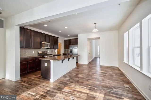 a kitchen with stainless steel appliances granite countertop a refrigerator stove top oven and sink