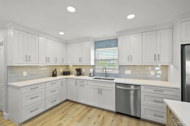 a kitchen with stainless steel appliances kitchen island granite countertop a stove and white cabinets