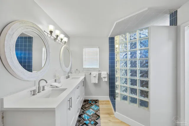 a spacious bathroom with a double vanity sink mirror and bathtub