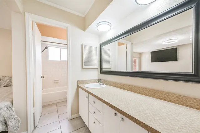 a spacious bathroom with a granite countertop sink and a mirror