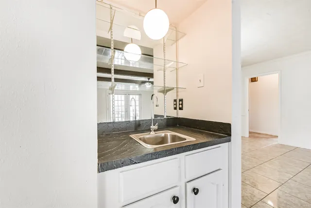 a kitchen with granite countertop a sink and a white cabinets