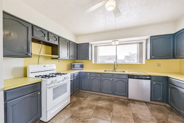 a kitchen with a stove sink and cabinets