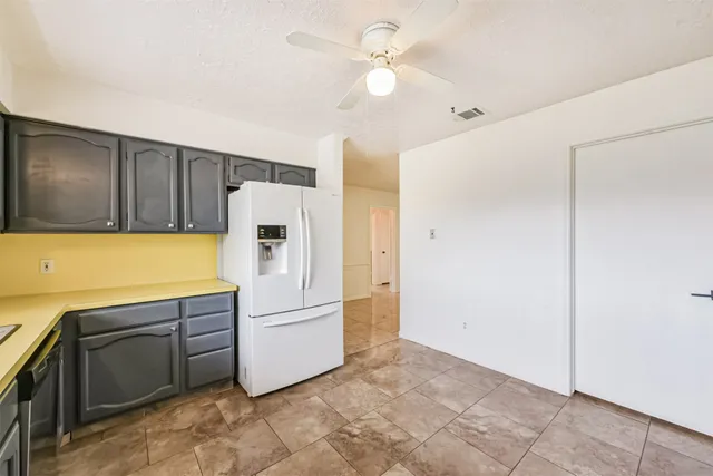 a kitchen with cabinets a refrigerator and a stove top oven