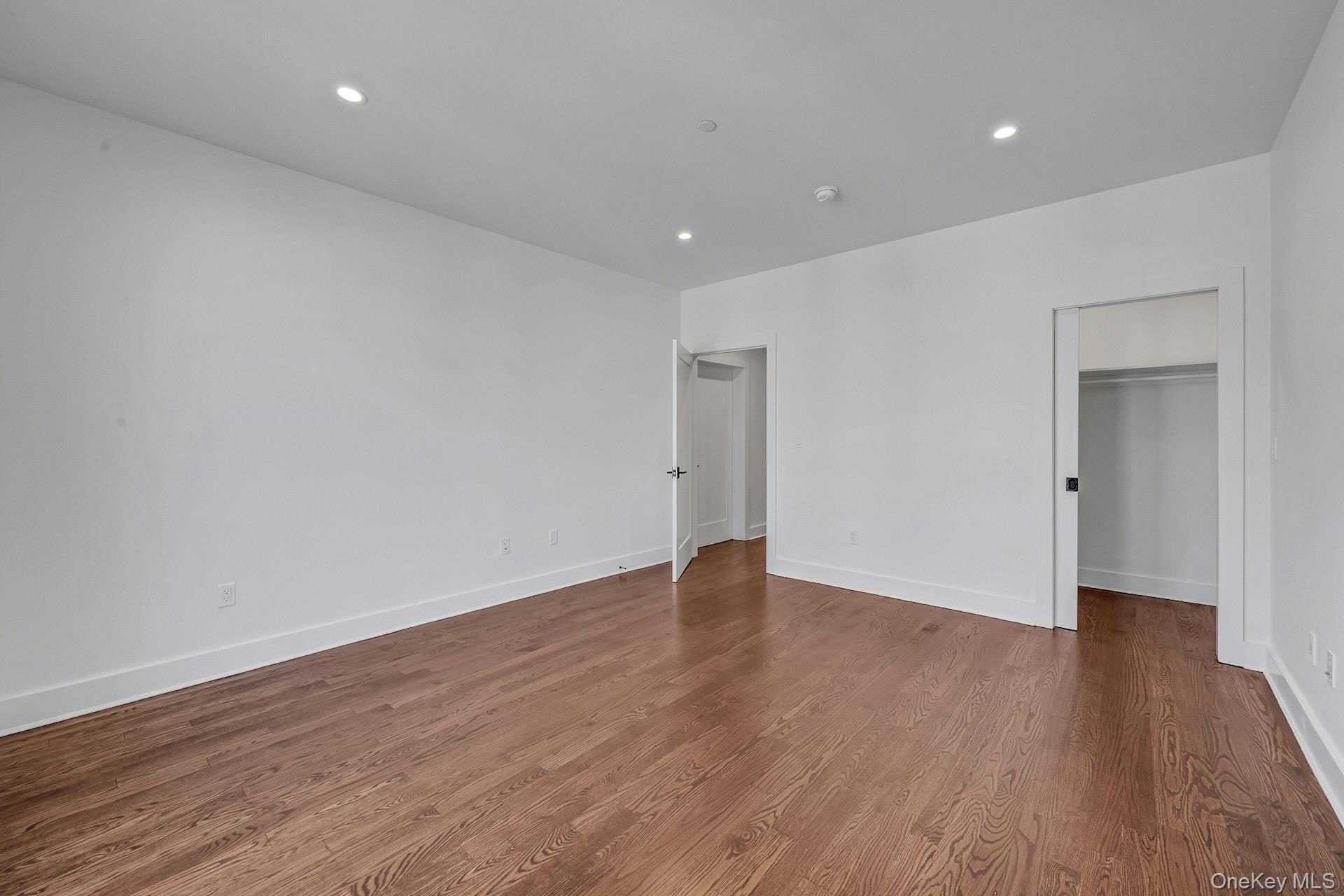 291 Main Street, Unit 1C Eastchester, NY 10709 - Photo 11 of 14 a view of an empty room with wooden floor and a window