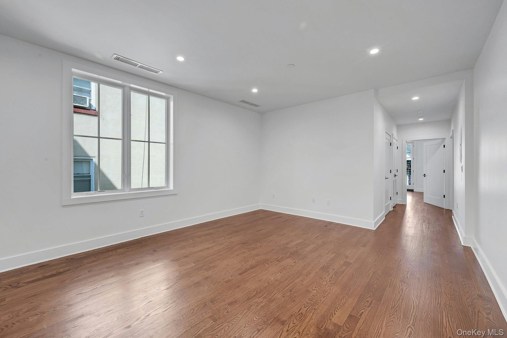 291 Main Street, Unit 1C Eastchester, NY 10709 - Photo 5 of 14 a view of empty room with wooden floor and fan